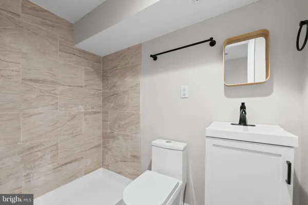 a bathroom with a toilet a sink and mirror