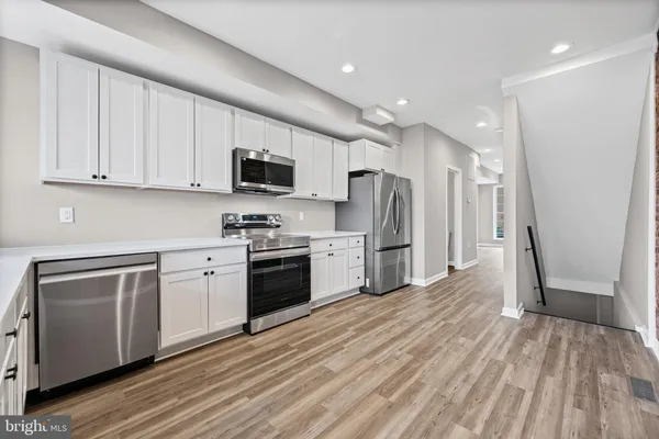 a kitchen with stainless steel appliances granite countertop a refrigerator a stove top oven a sink and dishwasher