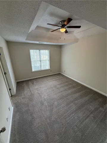 an empty room with windows and ceiling fan view