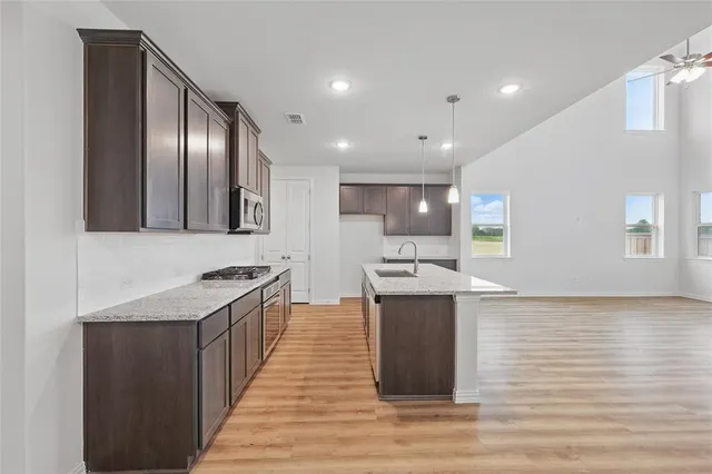 a kitchen with stainless steel appliances granite countertop a stove a sink and a refrigerator