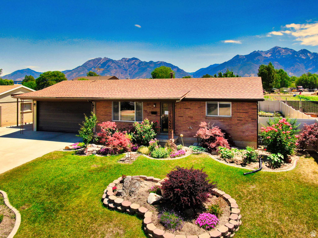 8097 South 535 East Sandy, UT 84070 - Photo 1 of 15 Brick exterior with a brown shingle roof, complemented by a concrete driveway and an attached garage