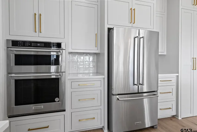 a kitchen with stainless steel appliances white cabinets and a stove