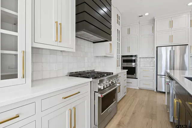 a kitchen with white cabinets and stainless steel appliances