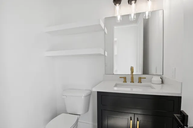 a bathroom with a sink toilet and mirror