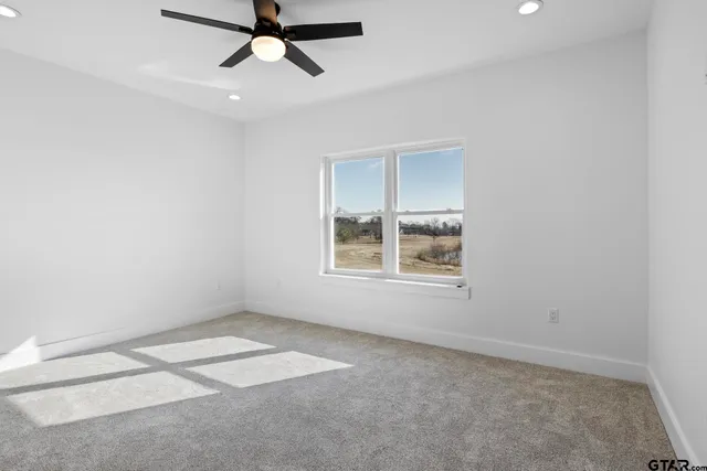 an empty room with a window and a fan