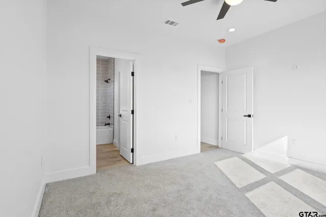 an empty room with closet and a ceiling fan