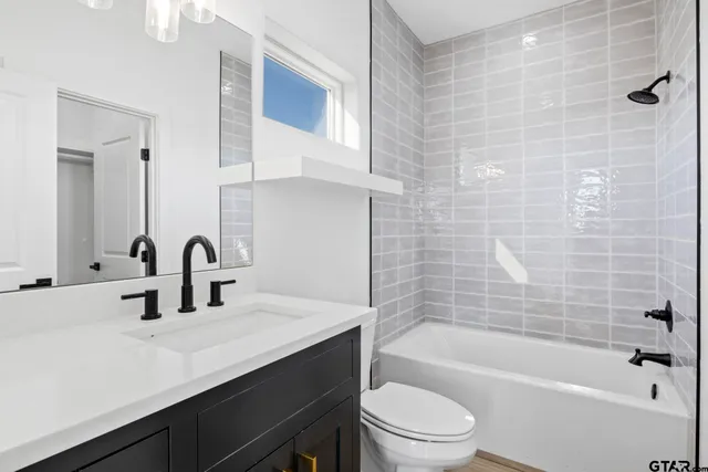 a bathroom with a bathtub shower sink vanity and toilet