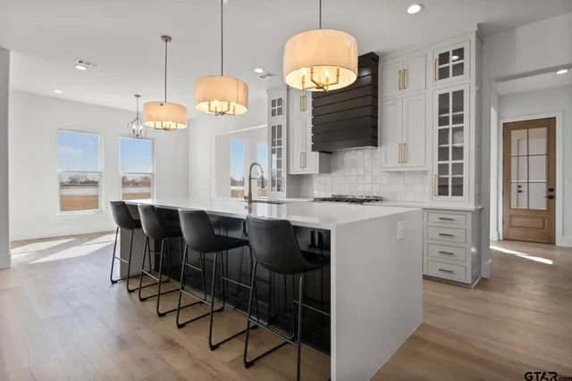 a kitchen with a dining table cabinets and wooden floor