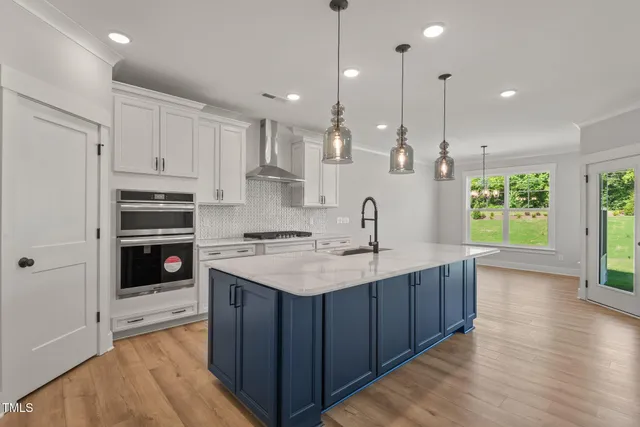 a kitchen with stainless steel appliances granite countertop a kitchen island a stove and a sink