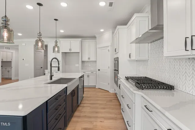 a kitchen with white cabinets sink and stainless steel appliances