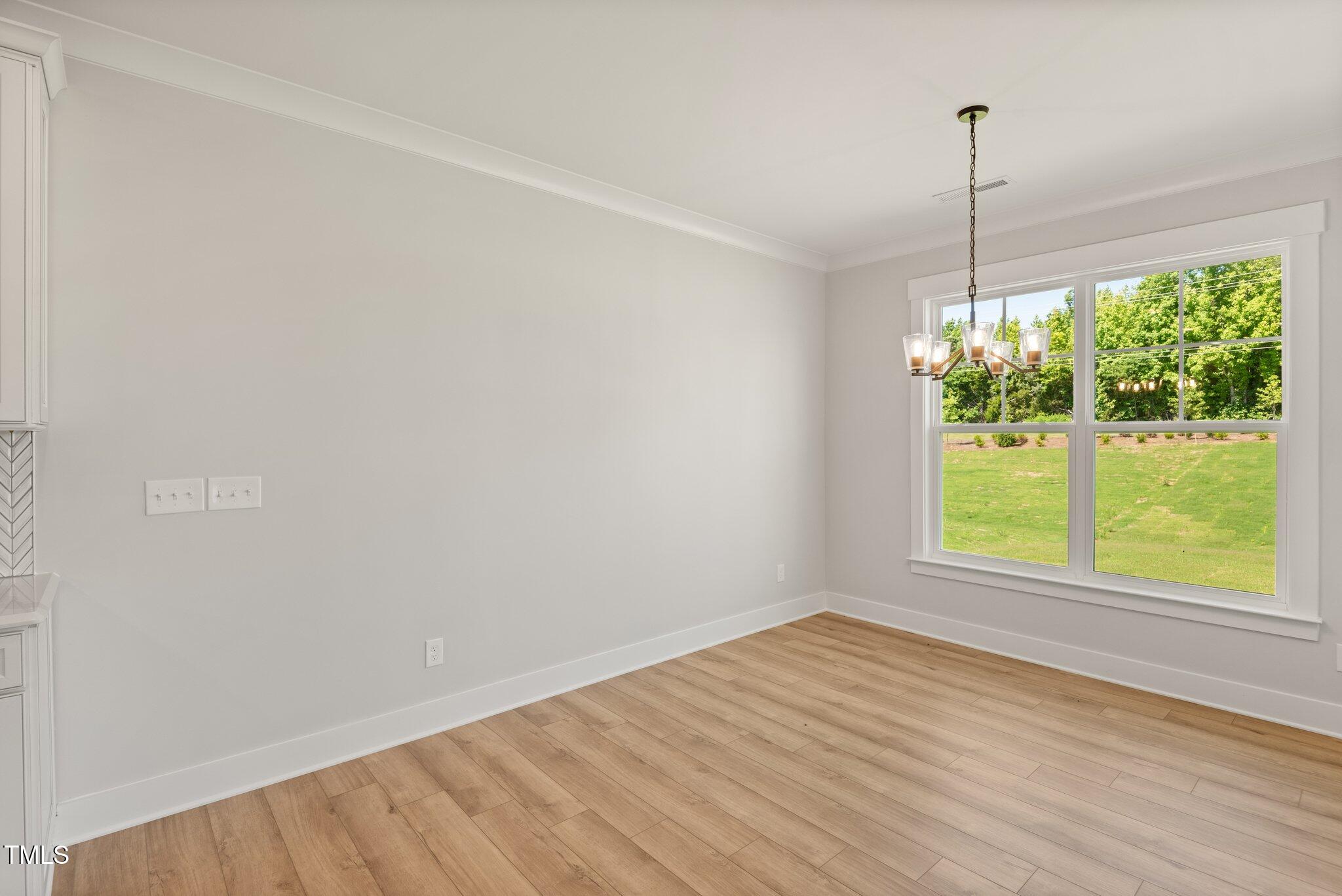 1306 Cricket Street Elon, NC 27244 - Photo 21 of 36 a view of an empty room with wooden floor and a window
