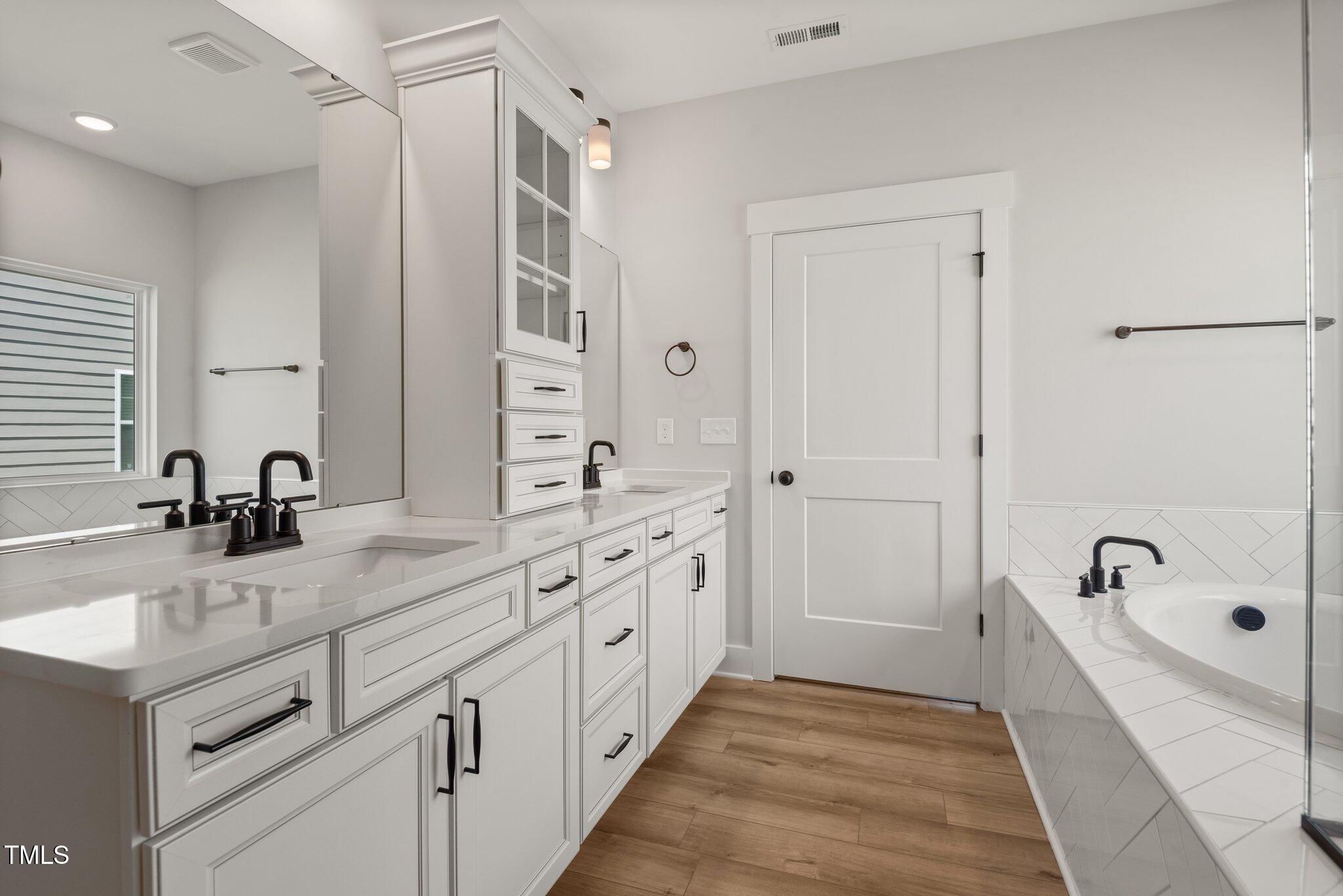 1306 Cricket Street Elon, NC 27244 - Photo 31 of 36 a spacious bathroom with a tub sink double vanity and mirror