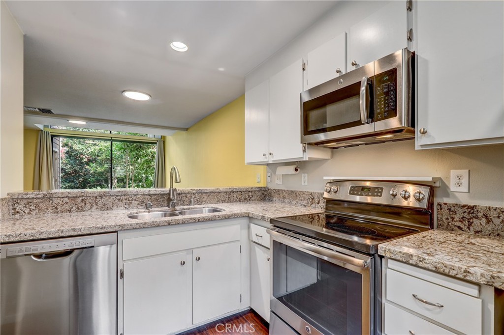 162 Pineview Irvine, CA 92620 - Photo 11 of 35 a kitchen with stainless steel appliances granite countertop a sink a stove a microwave a sink and cabinets