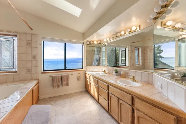 a spacious bathroom with a granite countertop tub sink and mirror