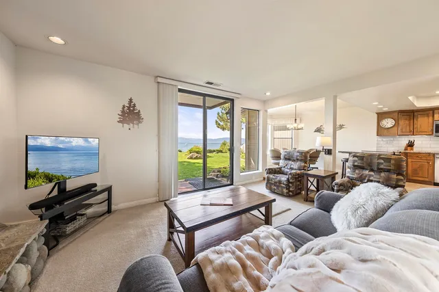a living room with furniture flat screen tv and a large window