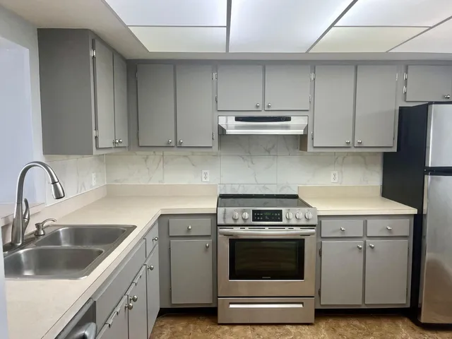 a kitchen with cabinets appliances and a sink