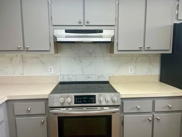 a kitchen with white cabinets and white appliances