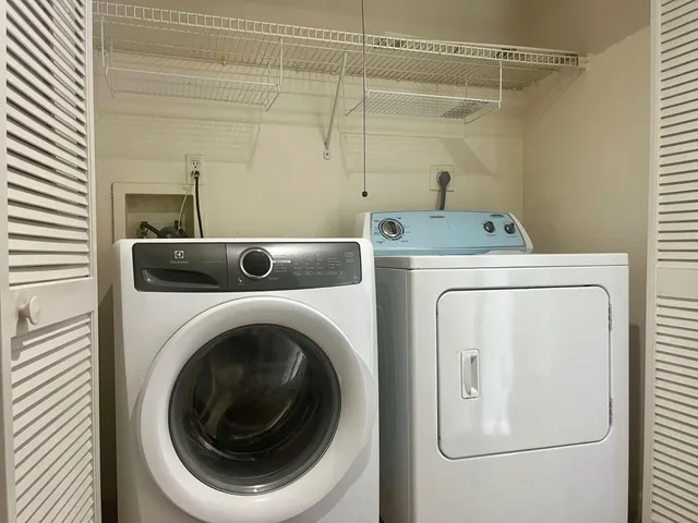 a view of a swimming pool with a lawn chairs under palm trees