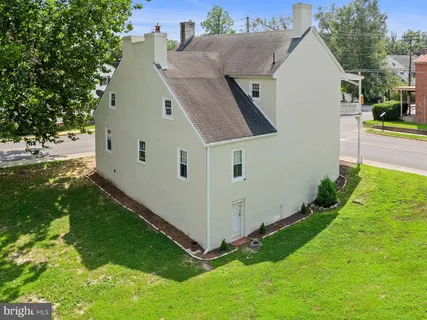 a view of a white house with a yard and potted plants