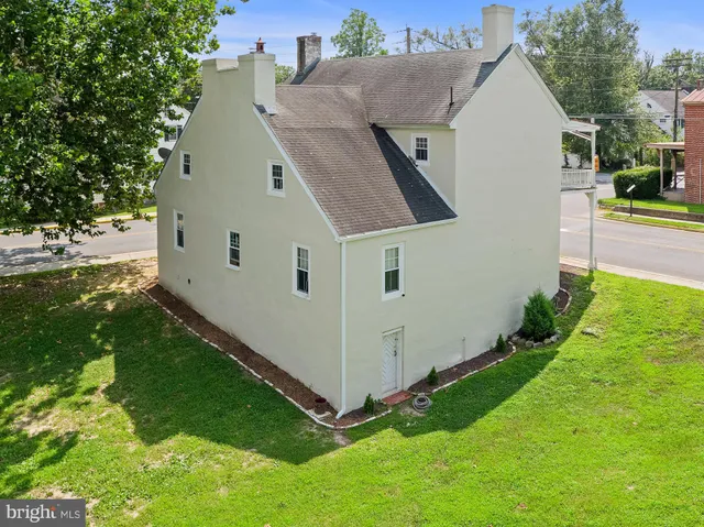 a view of a white house with a yard and potted plants