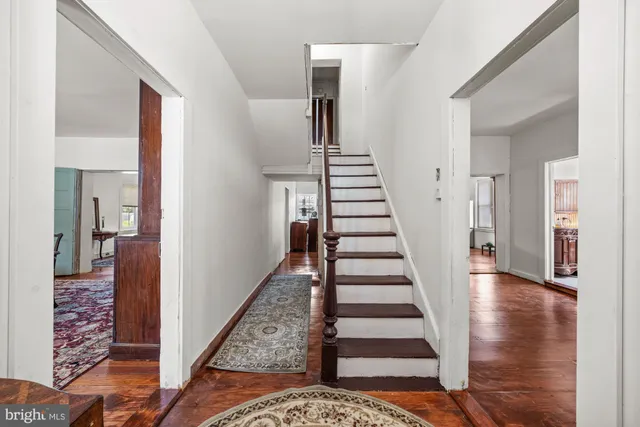 a view of a hallway to a livingroom and stairs