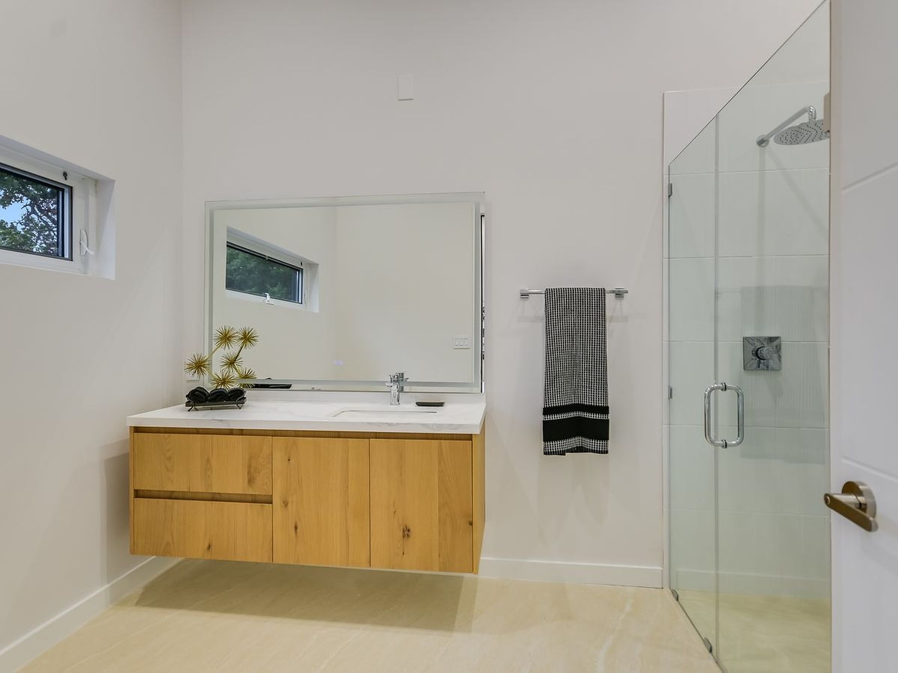 2476 Waymaker Way Austin, TX 78746 - Photo 17 of 31 A well-lit primary bathroom features a floating vanity, modern fixtures, and a spacious glass-enclosed shower.
