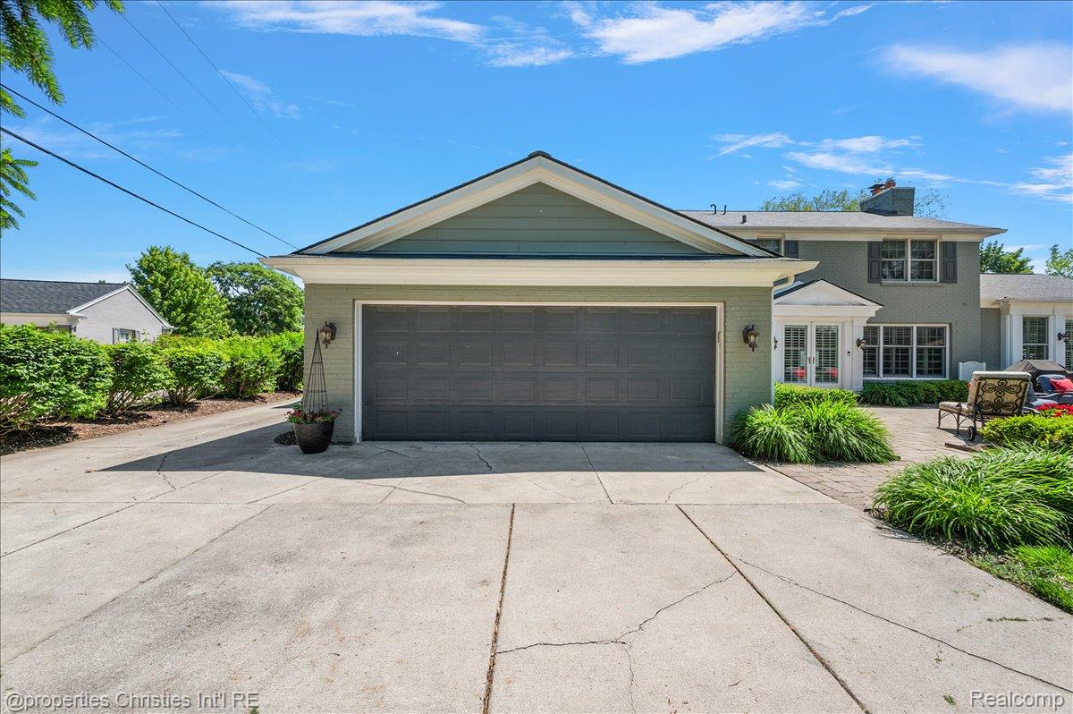 135 Clifton Road Bloomfield Hills, MI 48301 - Photo 67 of 77 Attached garage with a dark gray overhead door and light green siding