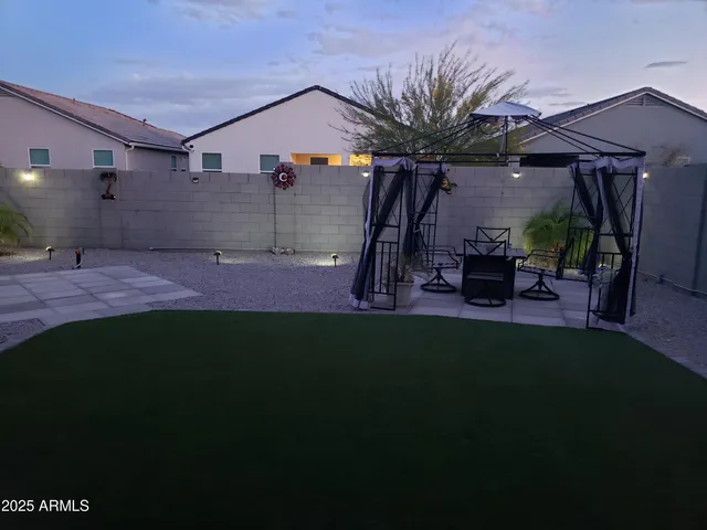 a view of a backyard with table and chairs under an umbrella
