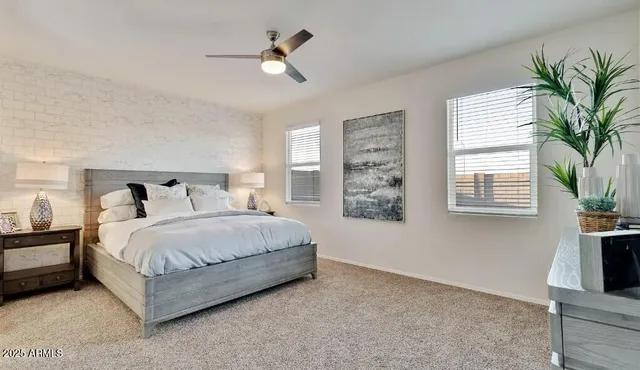 a bedroom with a bed lamp and a potted plant