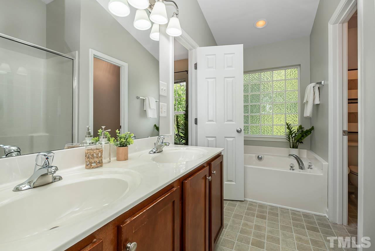1658 Snow Mass Way Durham, NC 27713 - Photo 19 of 26 a bathroom with a tub a sink and mirror