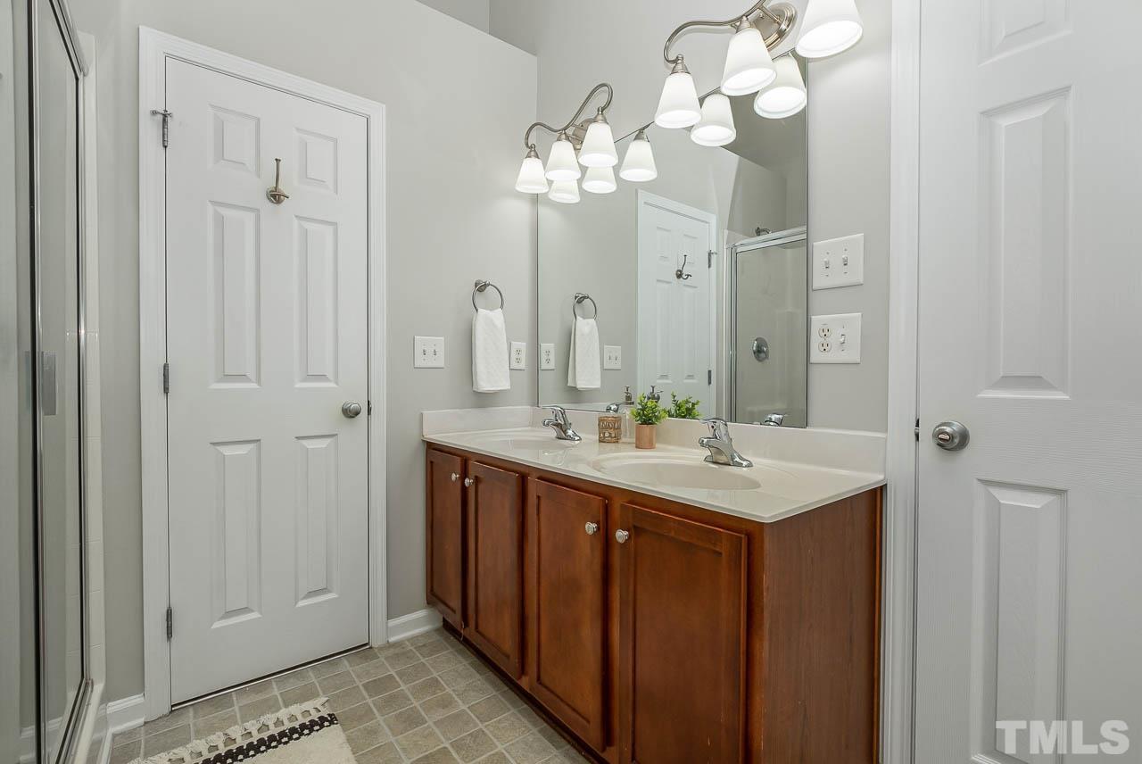 1658 Snow Mass Way Durham, NC 27713 - Photo 20 of 26 a bathroom with a double vanity sink and a mirror