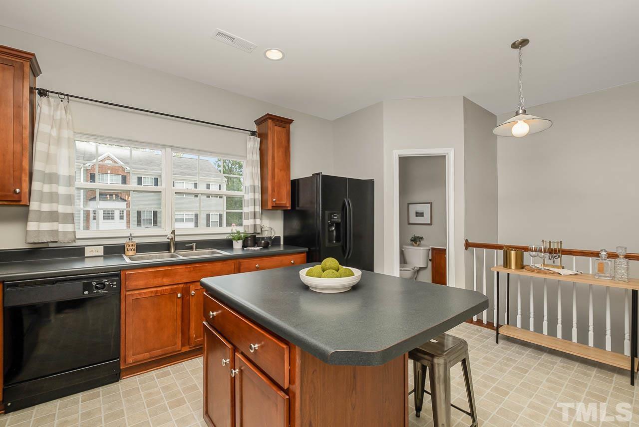1658 Snow Mass Way Durham, NC 27713 - Photo 8 of 26 a kitchen with a sink a stove and chairs
