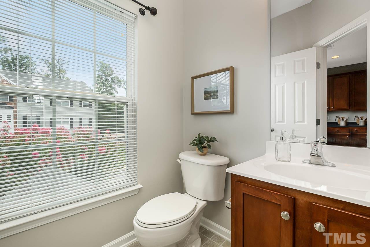 1658 Snow Mass Way Durham, NC 27713 - Photo 10 of 26 a bathroom with a toilet a sink and a large mirror