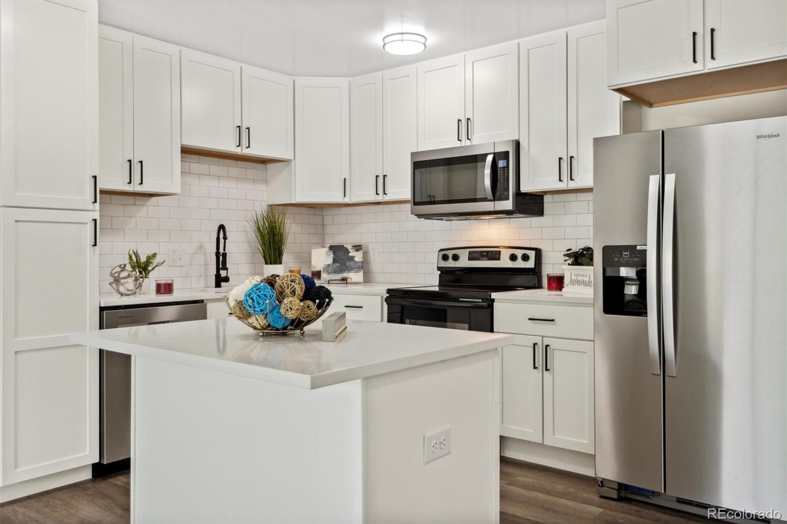 a kitchen with stainless steel appliances a white refrigerator a stove a microwave and sink