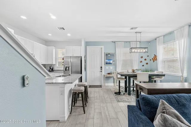 a kitchen with a dining table chairs stainless steel appliances and cabinets