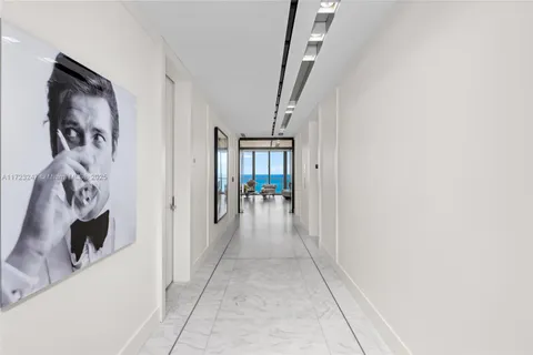 a view of a hallway with wooden floor and a living room