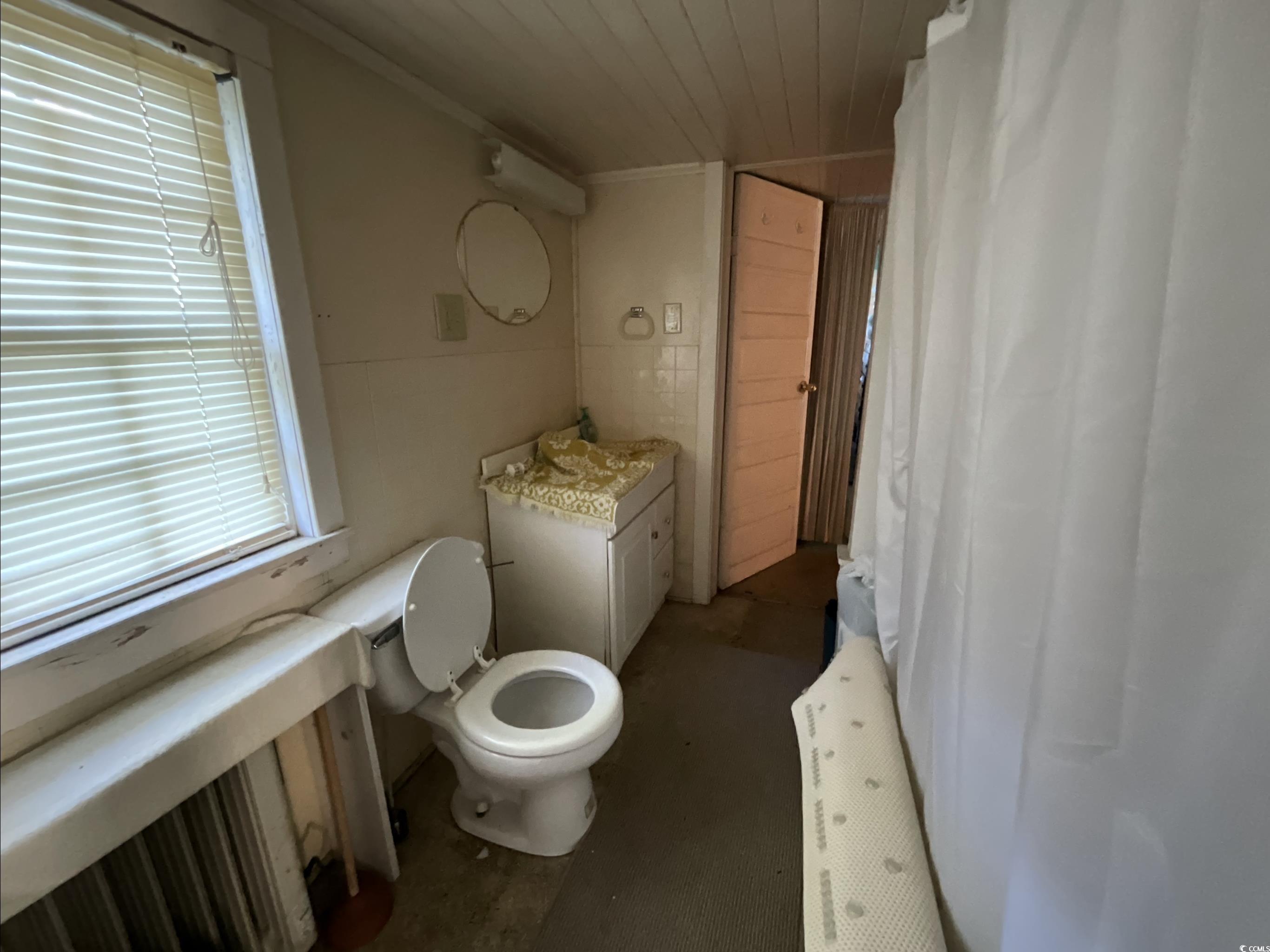 381 Retired Avenue Marion, SC 29571 - Photo 9 of 9 Bathroom featuring radiator heating unit, vanity, curtained shower, and tile walls