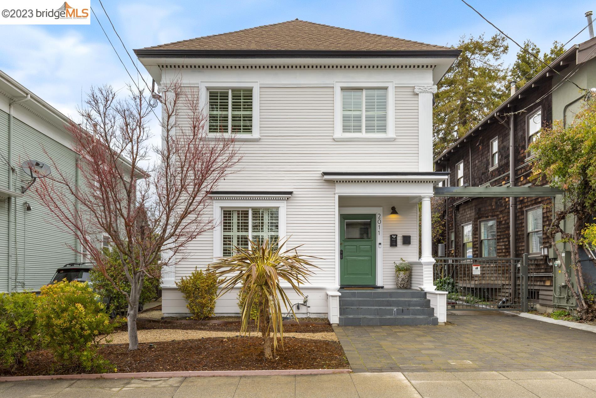 a front view of a house with a tree