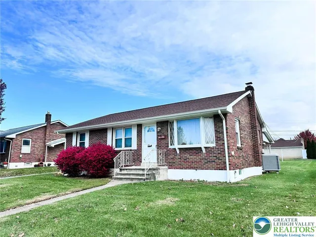 a front view of house with yard and green space