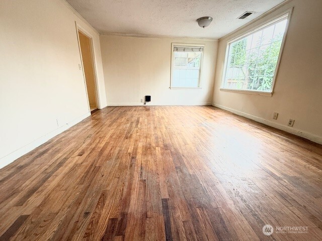 12018 Sand Point Way Northeast Seattle, WA 98125 - Photo 2 of 14 an empty room with wooden floor and windows