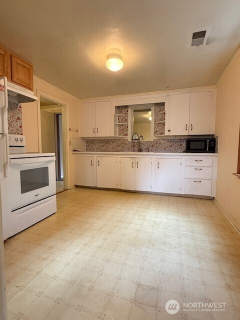 12018 Sand Point Way Northeast Seattle, WA 98125 - Photo 3 of 14 a kitchen with granite countertop a stove and a sink