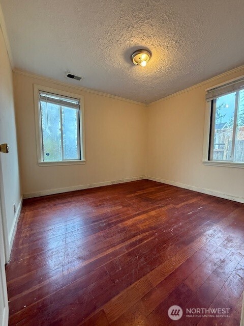 12018 Sand Point Way Northeast Seattle, WA 98125 - Photo 5 of 14 an empty room with wooden floor and windows