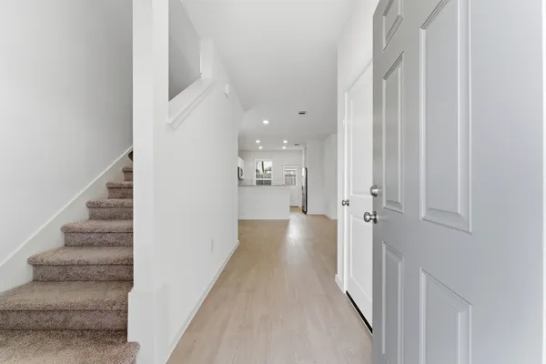 a view of a hallway with wooden floor and staircase