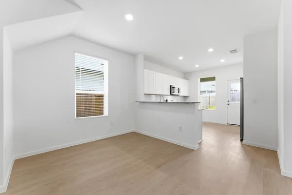 a view of a kitchen with wooden floor and windows