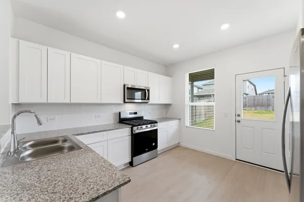 a kitchen with stainless steel appliances granite countertop a sink stove and refrigerator