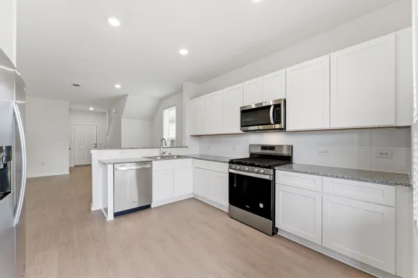 a kitchen with white cabinets and stainless steel appliances