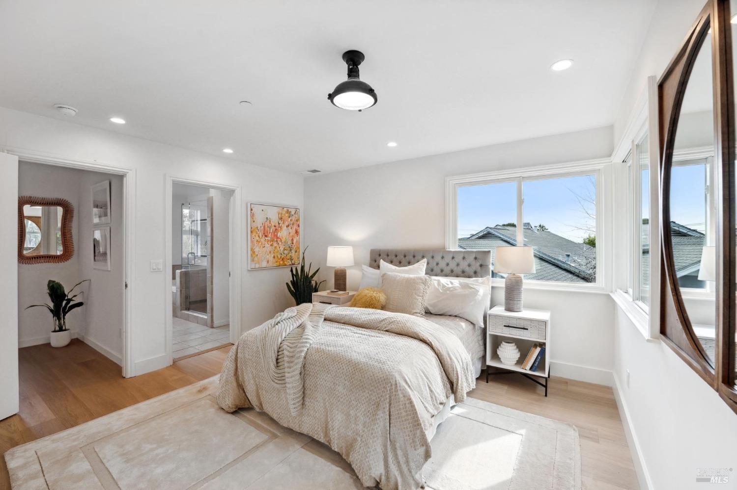 144 Richardson Drive Mill Valley, CA 94941 - Photo 21 of 43 a spacious bedroom with a large bed and a chandelier