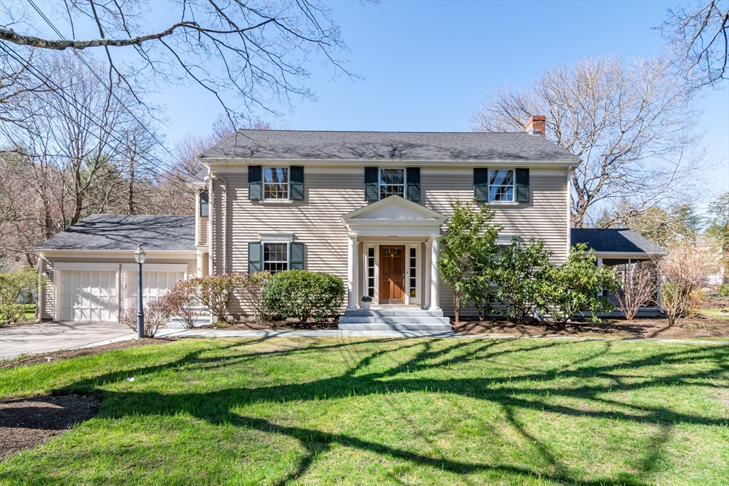a front view of a house with a yard and potted plants