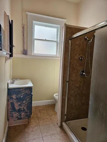 a bathroom with a shower a toilet and a sink