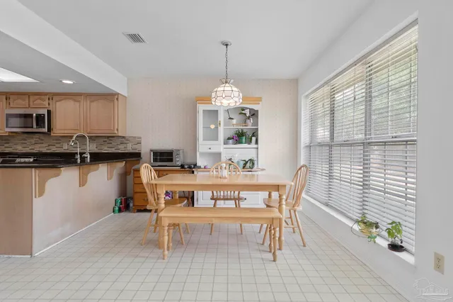 a dining room with furniture a chandelier and window